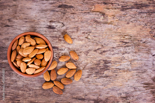 Almond. Almonds in a bowl on the old wooden background. photo