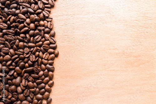 Coffee beans on wooden table texture with copy space