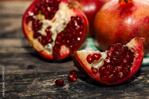 Sliced piece of pomegranate with second half in the background