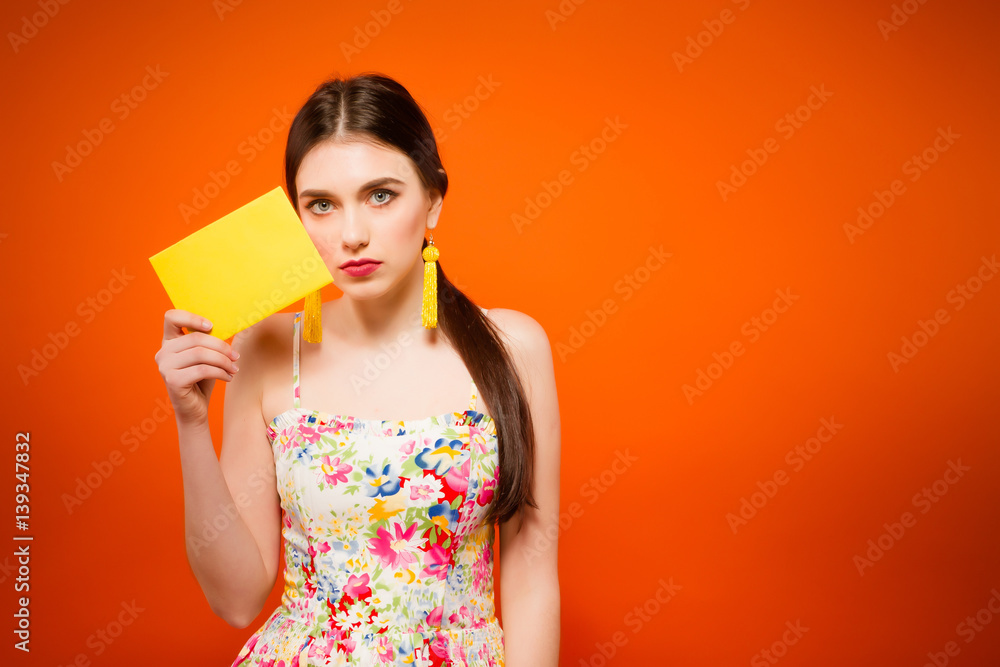 Beautiful woman with mail envelope. Over orange background.