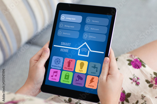 woman in flowered dress holding tablet with app smart home