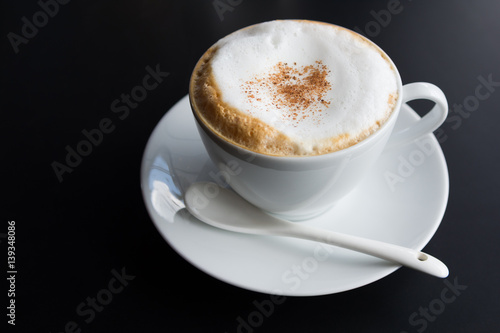Cappuccino coffee cup with foam on black background