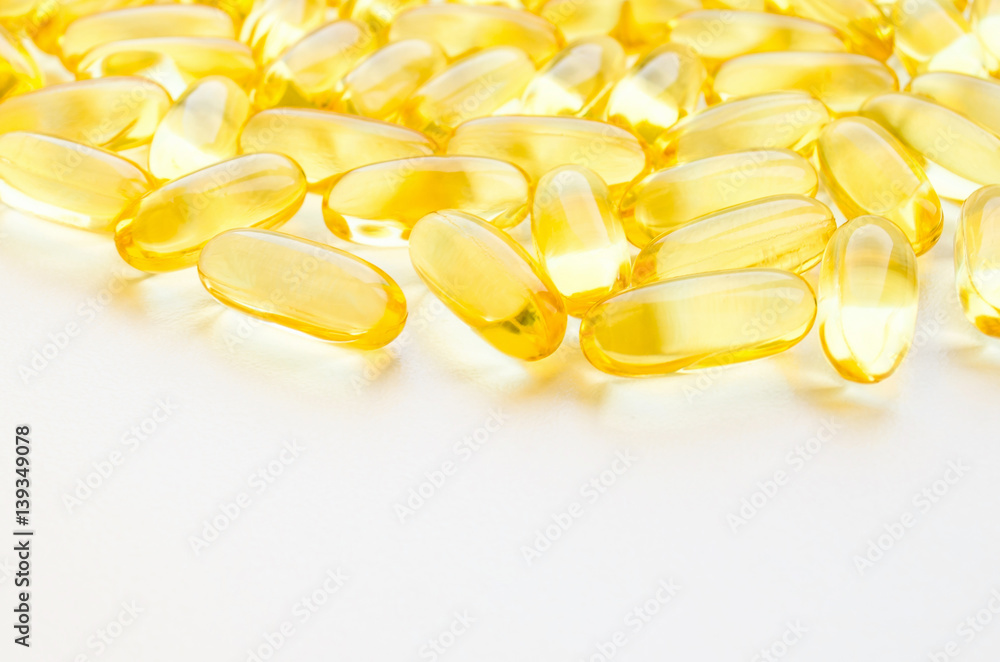 Fish oil fat capsules with omega 3 and vitamin D on white background, healthy diet concept Fish oil fat capsules with omega 3 and vitamin D on white background, healthy diet concept