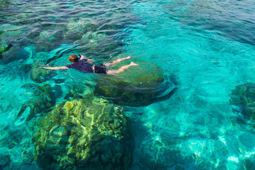 Foto auf Acrylglas Tauchen Young man snorkeling over coral reef in transparent tropical sea, Rok island, Thailand.  © Touchr