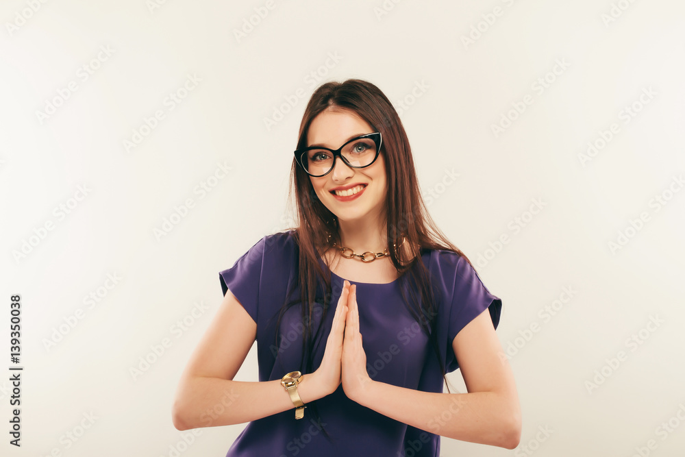 Portrait of a smiling woman wearing eye glasses. The palms together Portrait of a smiling woman wearing eye glasses. The palms together