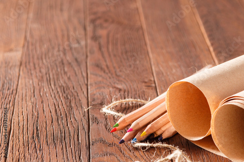 Blank brown paper and color pencils on wooden table with decorative rope photo