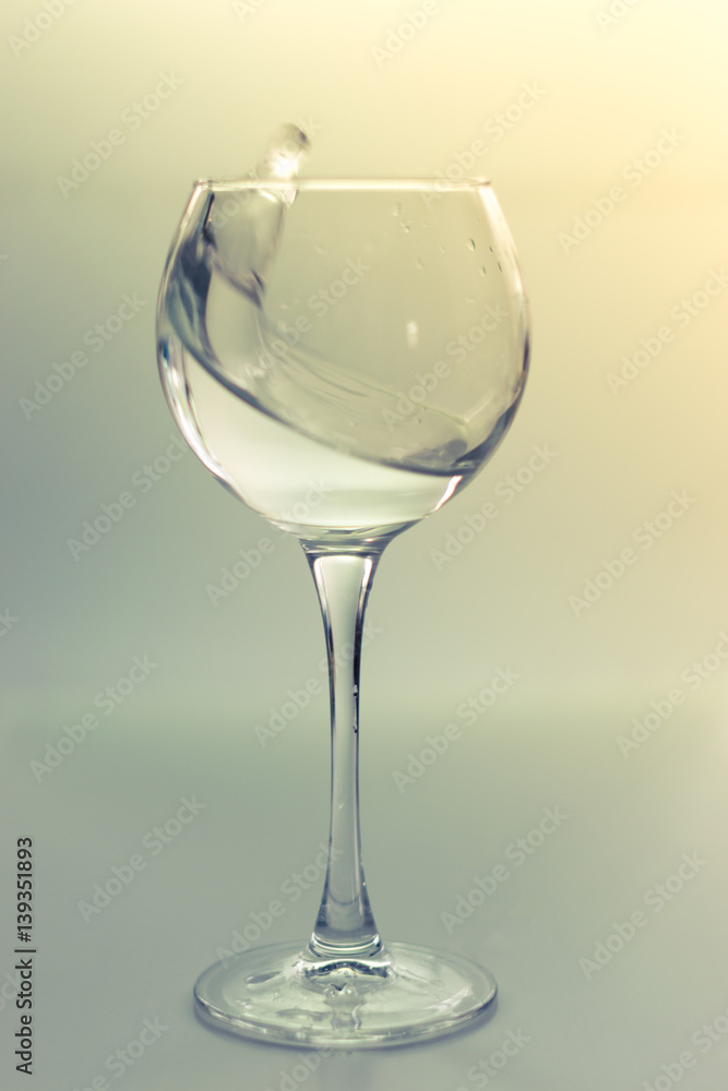 Splash water in a glass on a gray Splash water in a glass on a gray