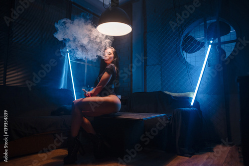 woman vaping. sexy brunette with Electronic Cigarette. vapor concept photo
