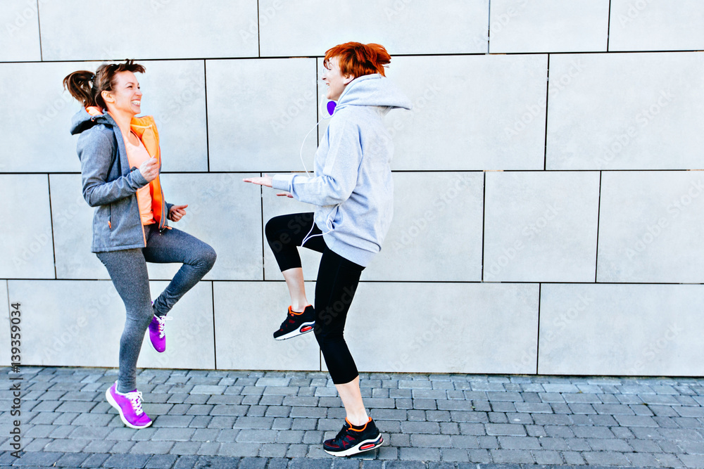 Fototapeta premium Two sporty women face to face exercising for marathon and workout fitness