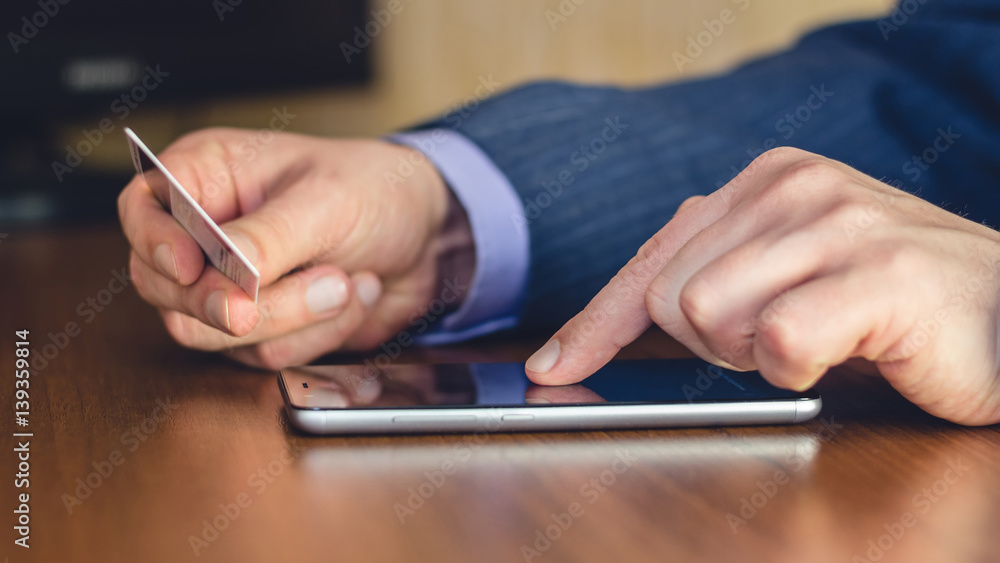 Formal wear, man hands using smartphone and holding credit card for online shopping and payment, selective focus. Formal wear, man hands using smartphone and holding credit card for online shopping and payment, selective focus.