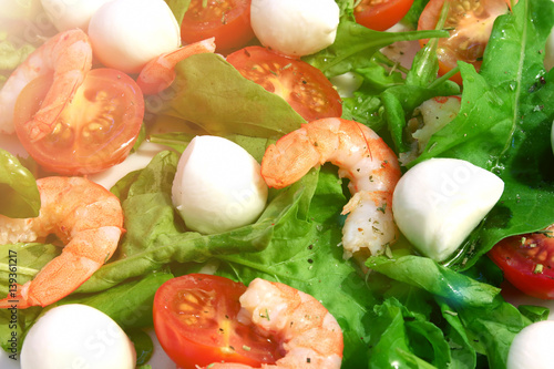 Salad with shrimp, arugula, mozzarella and cherry tomatoes close-up