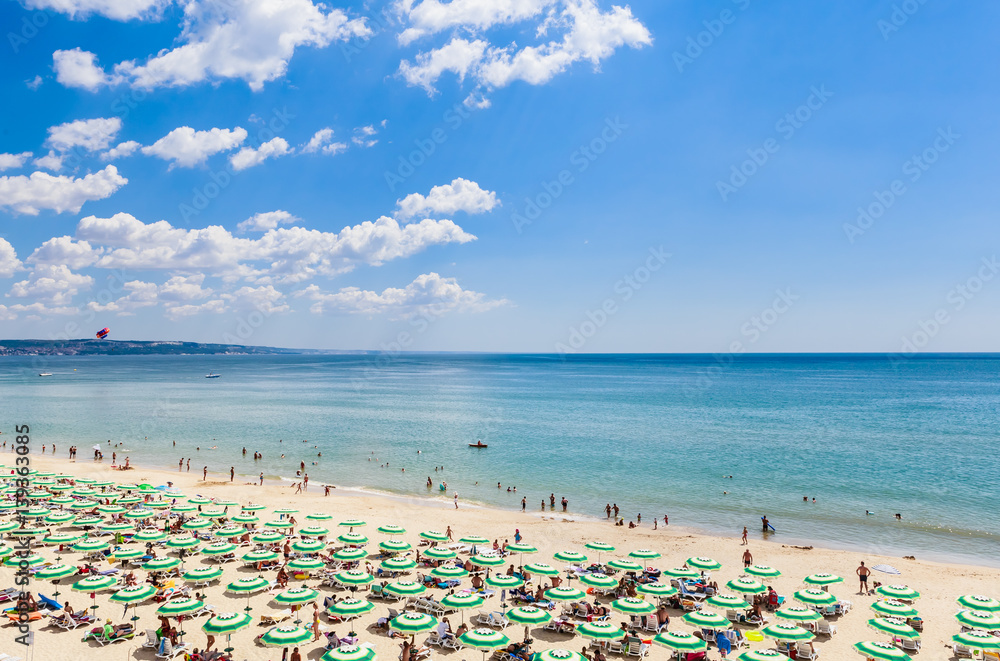 The Black Sea shore, blue clear water, beach with sand, umbrellas and sunbeds. Albena, Bulgaria The Black Sea shore, blue clear water, beach with sand, umbrellas and sunbeds. Albena, Bulgaria