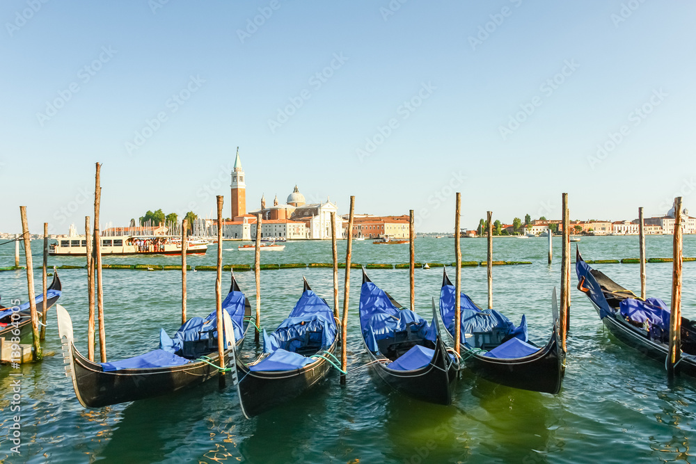 Gondolas moored by Saint Mark square with San Giorgio di Maggiore church in the background, Venice, Italy