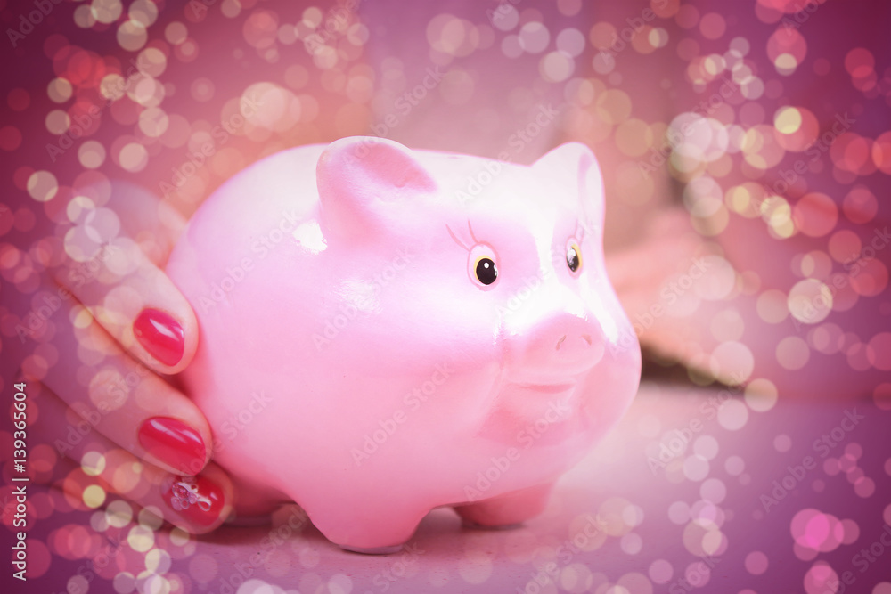 Hands holding a piggy bank with bokeh Hands holding a piggy bank with bokeh