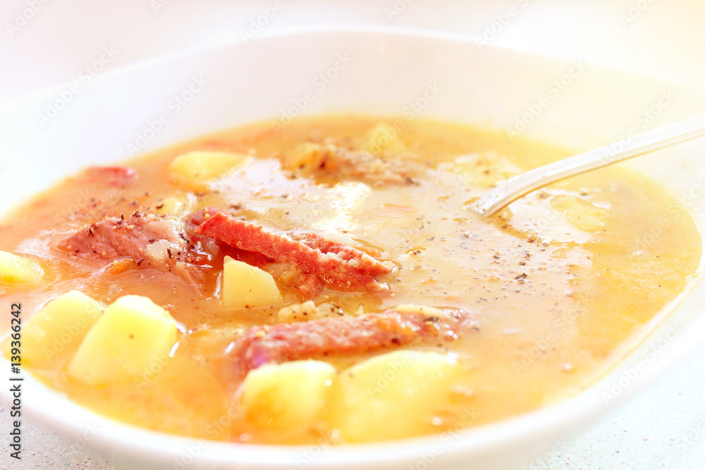 Appetizing pea soup with potatoes and meat close-up Appetizing pea soup with potatoes and meat close-up