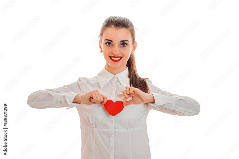 beautiful young girl vbeloj shirt and red lipstick on lips holding a card in the shape of a heart and smiling beautiful young girl vbeloj shirt and red lipstick on lips holding a card in the shape of a heart and smiling