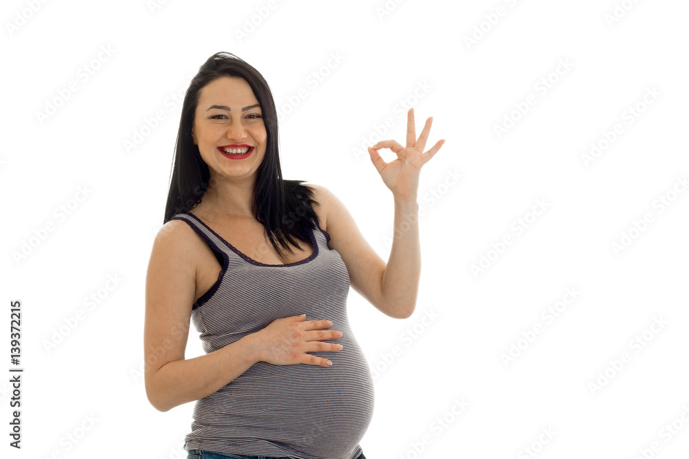 beautiful young pregnant woman smiles and shows the hand gesture beautiful young pregnant woman smiles and shows the hand gesture