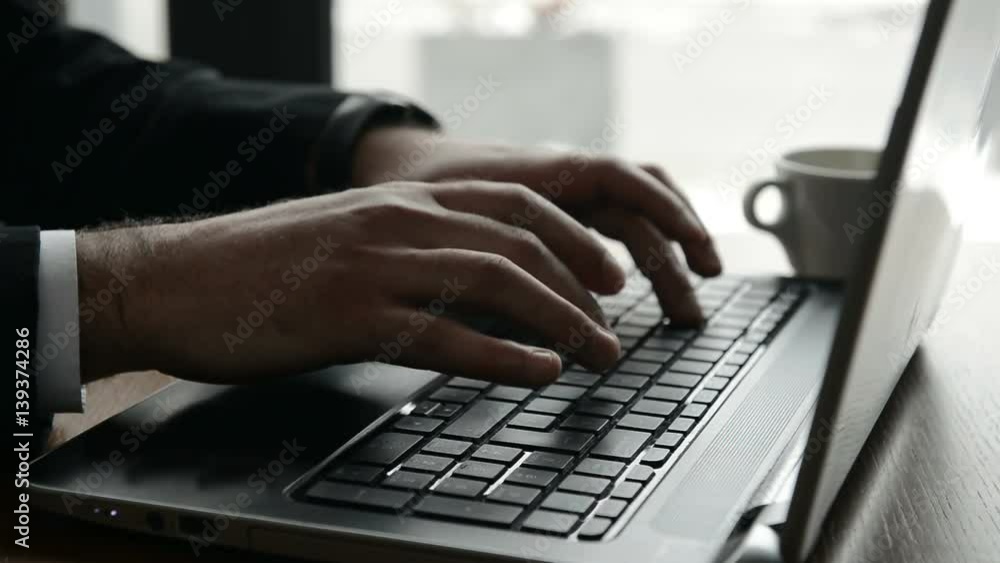Businessman is typing on laptop and having coffee Businessman is typing on laptop and having coffee