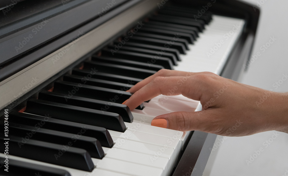 Woman playing the piano, part of hand, learning to play Woman playing the piano, part of hand, learning to play