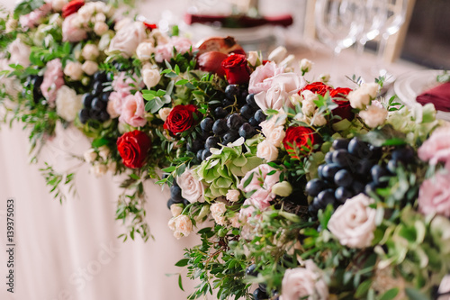 Wedding table decoration with the pink flowers, grape and greenery