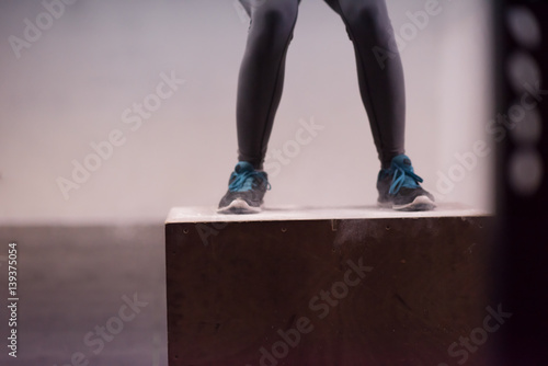 black woman is performing box jumps at gym