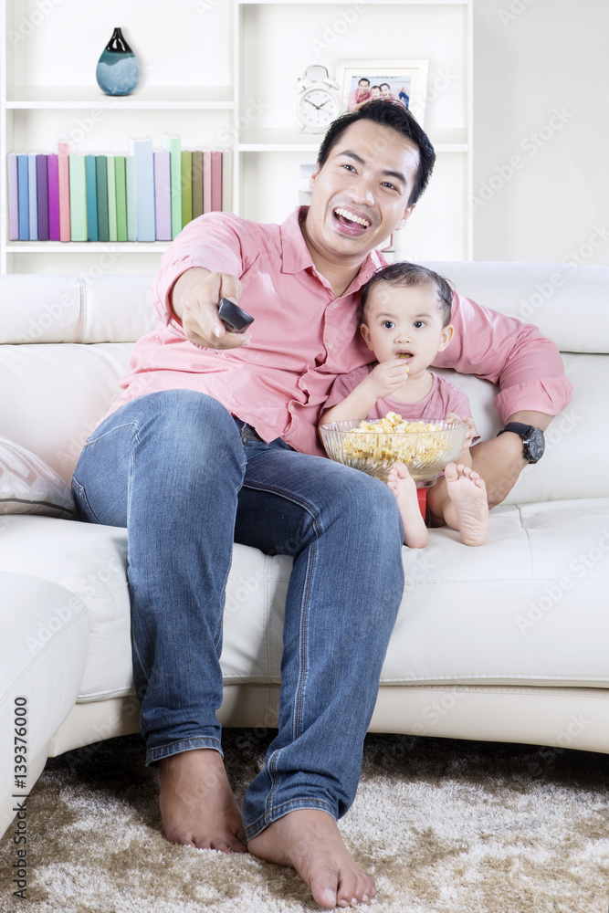 Father watching tv with daughter at home Father watching tv with daughter at home
