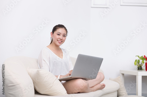 young pretty woman using laptop on sofa