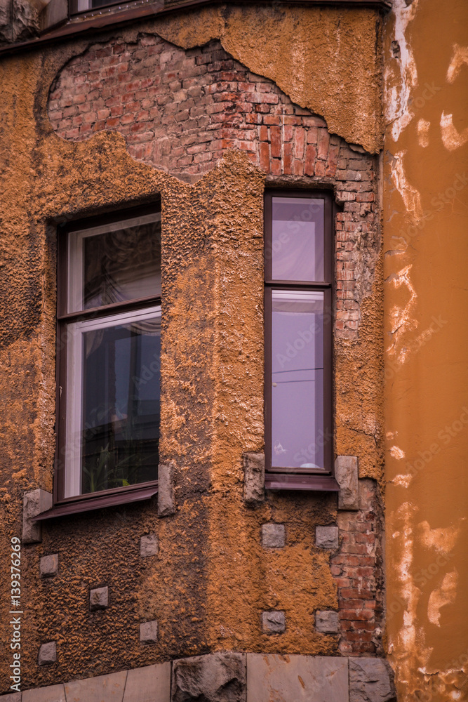 Windows in an old house with the broken colorful facade