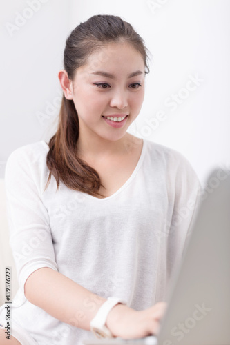 young pretty woman using laptop on sofa
