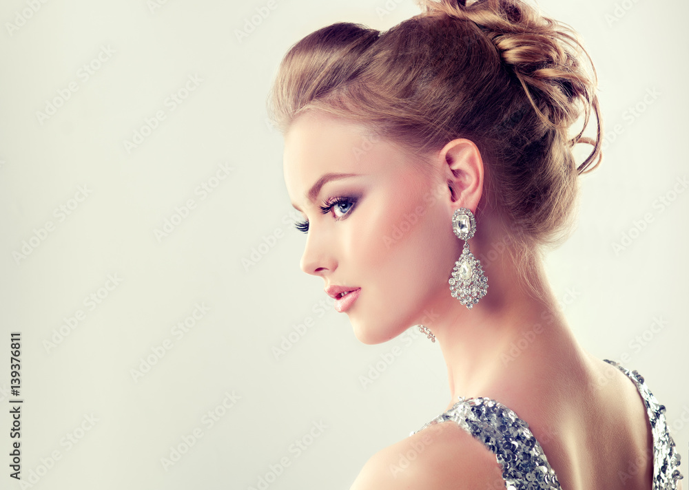 Beautiful girl with elegant hairstyle and big earrings jewelry . Stock