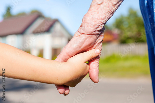 grandmother taking hand of young child, concept