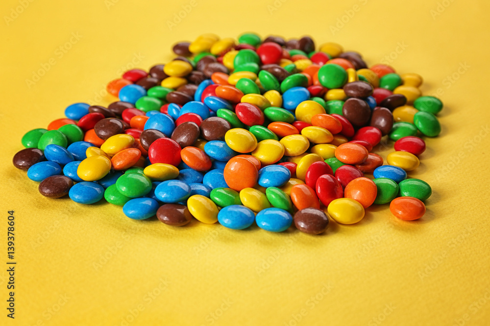 Tasty colorful candies on yellow background Tasty colorful candies on yellow background
