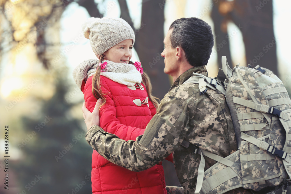 Fototapeta premium Soldier in camouflage with his daughter outdoors