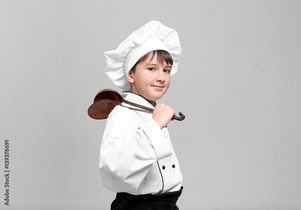 Cute boy in chef uniform on light background Cute boy in chef uniform on light background