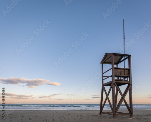 Beach sunrise with lifeguard wood tower