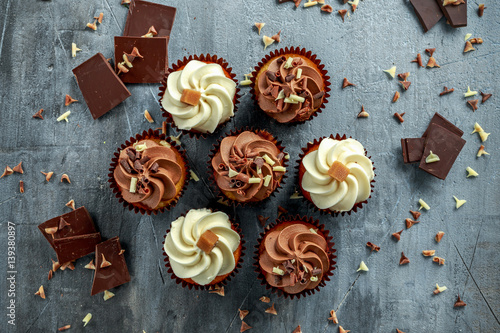 Chocolate and vanilla caramel cupcakes served with dark and white chocolate chippings