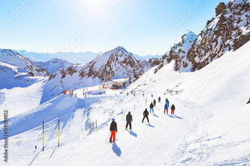 skiers on beautiful ski slope in Alps, people on  winter holidays