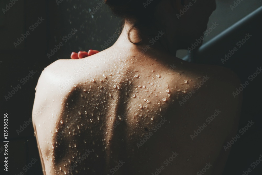 Foto Stock Schiena di donna sotto la doccia | Adobe Stock