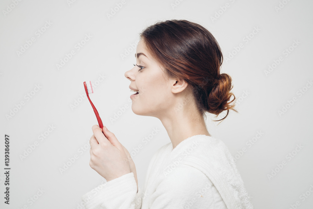 a woman looks at the toothbrush with admiration a woman looks at the toothbrush with admiration