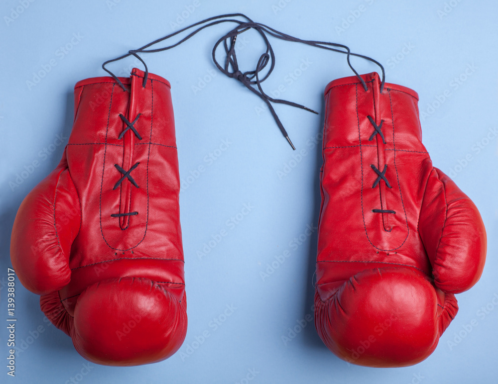 red boxing gloves with copy space in center isolated on blue background