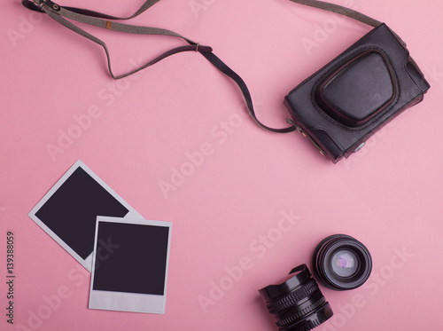 blank photo frames, vintage photo camera bag, lenses around blank copy space isolated on pink background, flat lay
