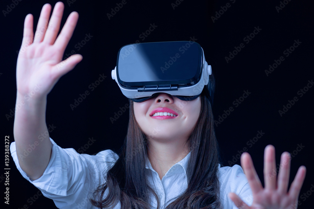 Asian Chinese young woman using vitual reality smart glasses in vitual space.low key photo Asian Chinese young woman using vitual reality smart glasses in vitual space.low key photo