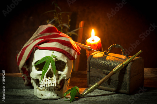 Pirate comedian skull with cannabis, marijuana in black still life style