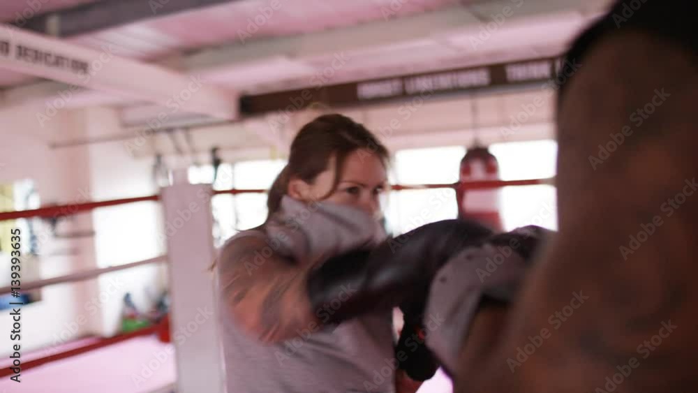 4K Female boxer fight training in the ring with pads, in slow motion 4K Female boxer fight training in the ring with pads, in slow motion
