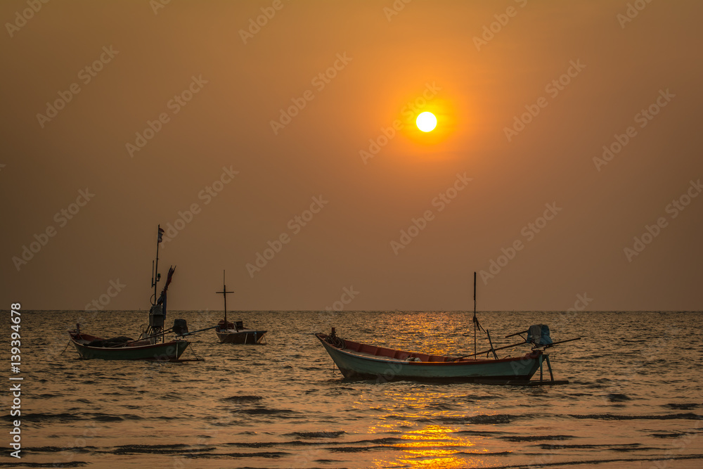 Small fishing boats in the sea, Sunset at Chao Lao Beach, Chanthaburi, Thailand.