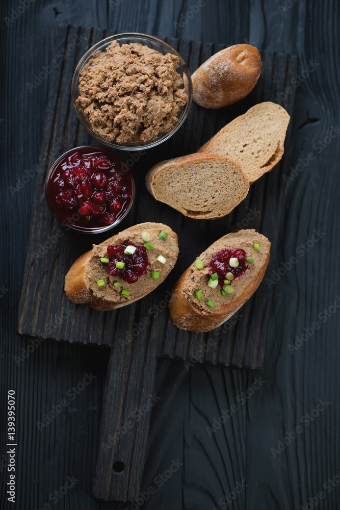 Black wooden serving board with chicken liver pate sandwiches and cranberry sauce, high angle view Black wooden serving board with chicken liver pate sandwiches and cranberry sauce, high angle view