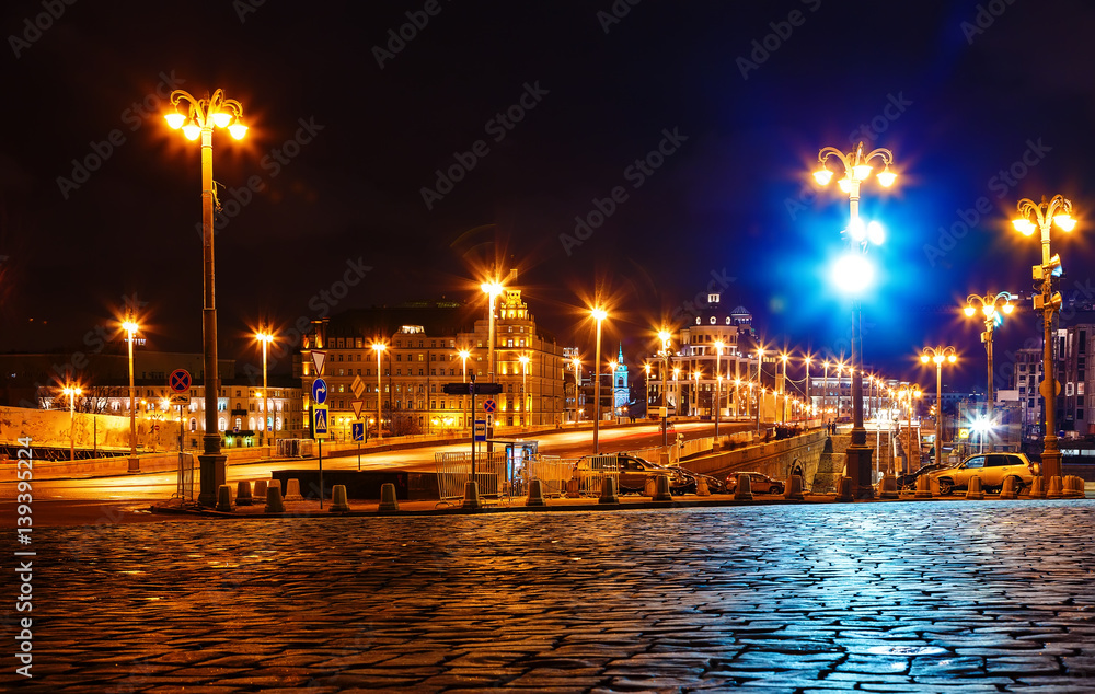 Night view with street lighting on the bridge leading to red square Moscow, Russia. The pavement in foreground.