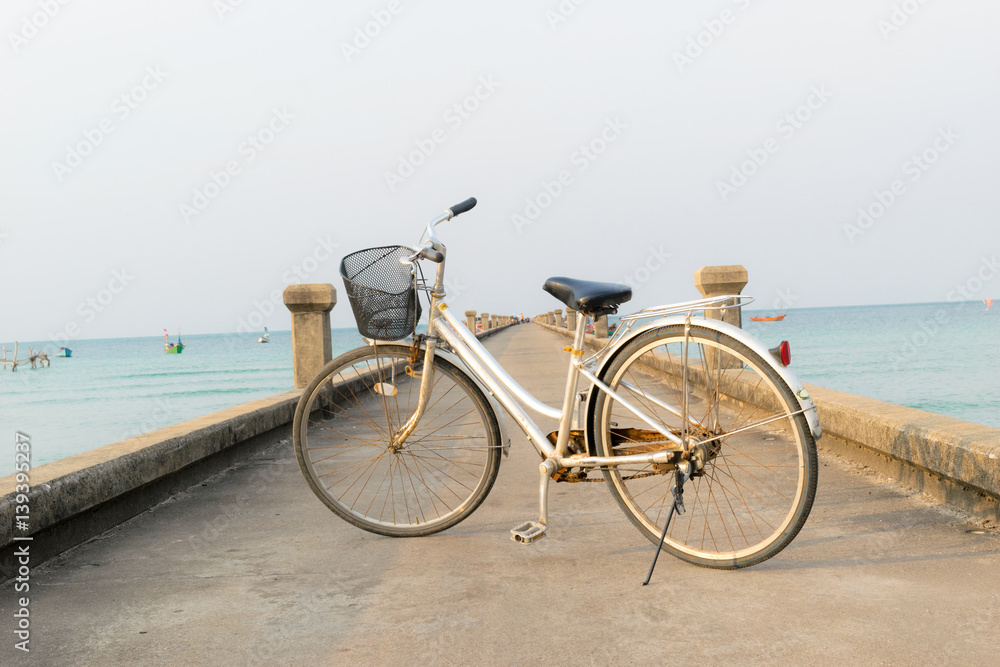 Bicycles parked on a bridge in the sea.