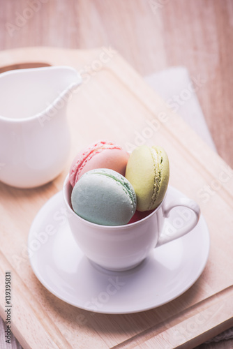 A lot of french colorful macarons on a woody floor,macarons in a cup