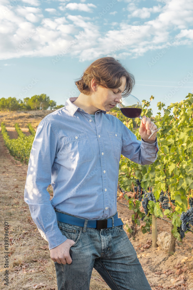 Winemaker tasting his wine in vineyard